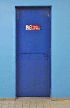 No entry sign on a blue firewall door - in Italian