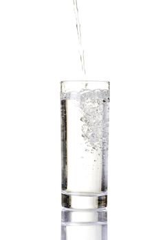 Pouring water on a glass on white background