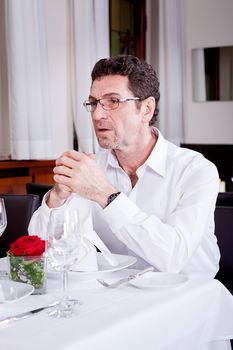 happy smiling couple in restaurant for dinner sitting talking drinking