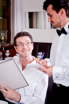 man and woman in restaurant waiter bring card and order food