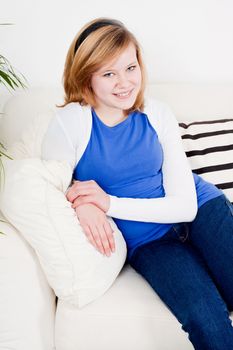happy teenager girl smiling sitting on couch and relaxing lifestyle leisure