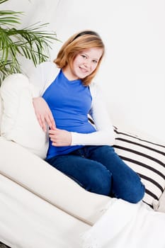 happy teenager girl smiling sitting on couch and relaxing lifestyle leisure