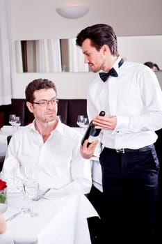 man and woman in restaurant for dinner drinking red wine and smiling