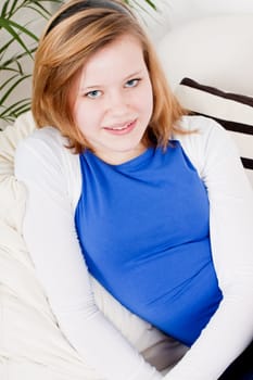 happy teenager girl smiling sitting on couch and relaxing lifestyle leisure