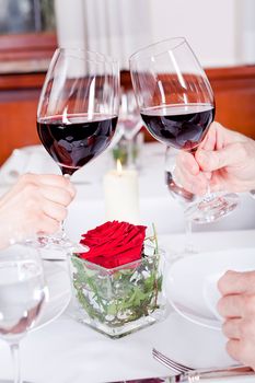 man and woman in restaurant for dinner drinking red wine and smiling