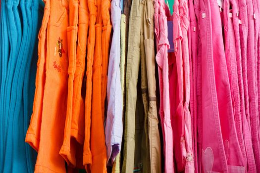 a lot of bright children's clothing on a hanger in the store