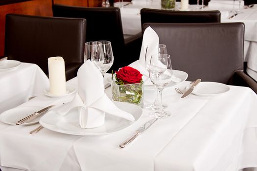 tables in restaurant with white tablecloth and elegant dish and silverwear