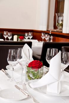 tables in restaurant with white tablecloth and elegant dish and silverwear