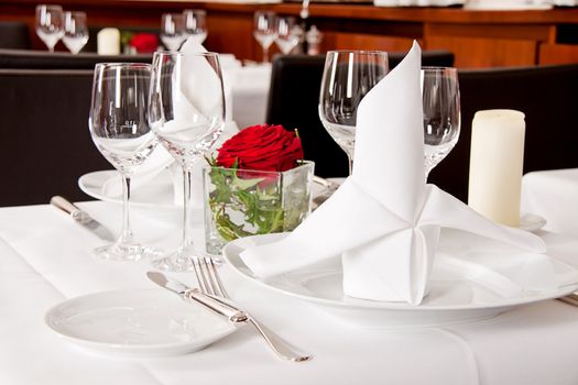 tables in restaurant with white tablecloth and elegant dish and silverwear