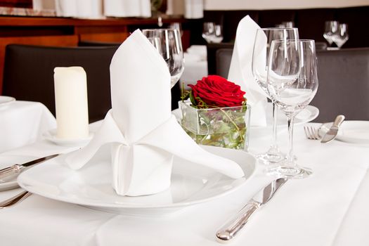 tables in restaurant with white tablecloth and elegant dish and silverwear