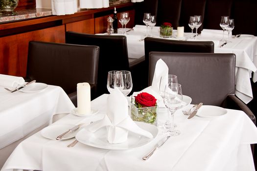 tables in restaurant with white tablecloth and elegant dish and silverwear