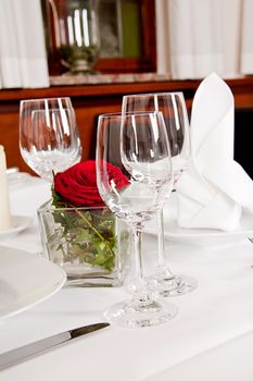 tables in restaurant with white tablecloth and elegant dish and silverwear