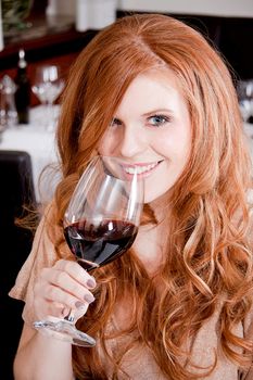 man and woman in restaurant for dinner drinking red wine and smiling