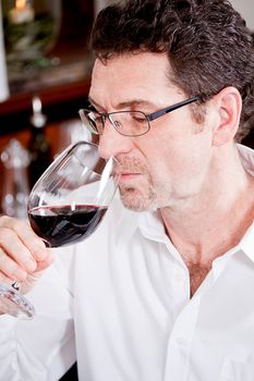 man and woman in restaurant for dinner drinking red wine and smiling