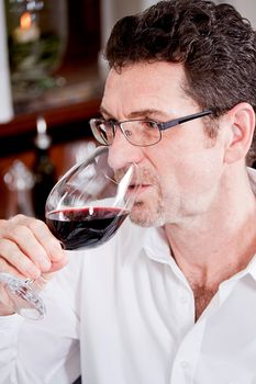 man and woman in restaurant for dinner drinking red wine and smiling