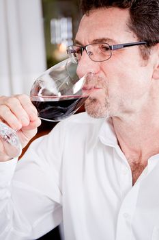 man and woman in restaurant for dinner drinking red wine and smiling