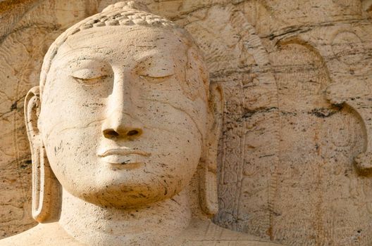 Buddha face on yellow stone background, Polonnaruwa, Sri Lanka 
