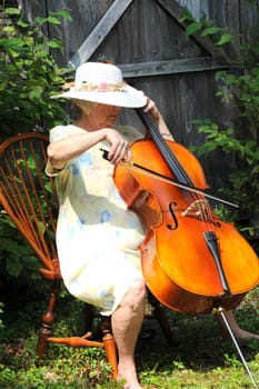 Female cellist with her cello outdoors.