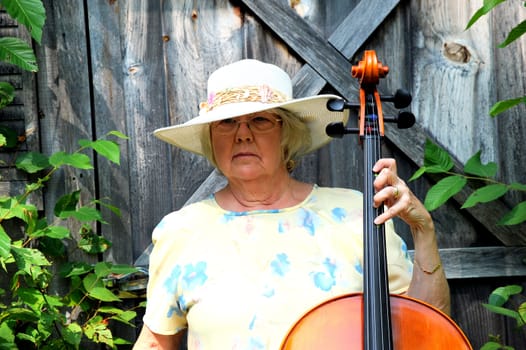 Female cellist with her cello outdoors.