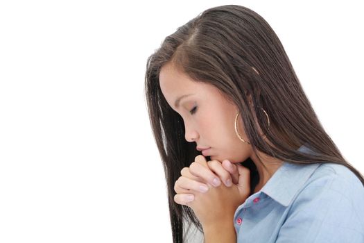 A young woman praying with her hands together on white background