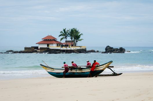 HIKKADUWA, SRI LANKA - DEC 13: Boat transport for cross to Seenigama Temple on Dec 13, 2011 in Hikkaduwa, Sri Lanka. It is known as the Seenigama Devalaya and is a popular as Galle tourist attraction.