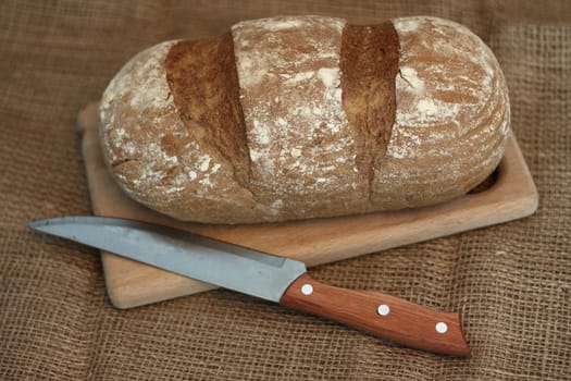Traditional black rye bread and knife shallow DOF