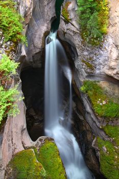 Smooth waterfall flows through Maligne Canyon of Jasper National Park in Canada.