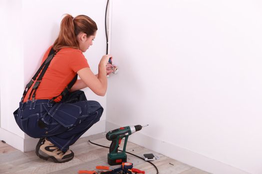 young woman installing electricity in a house