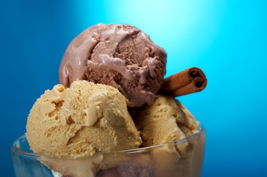ice cream in with strawberries and chocolate. closeup .on blue background.