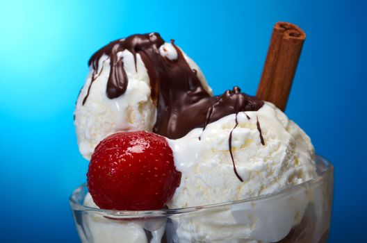 ice cream  with strawberries and with chocolate sauce closeup .on blue background.
