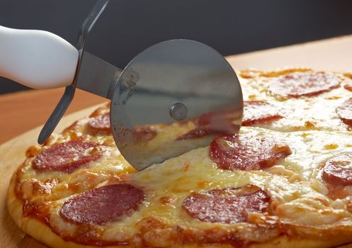homemade pizza  Pepperoni.Closeup  a knife cut the pizza 