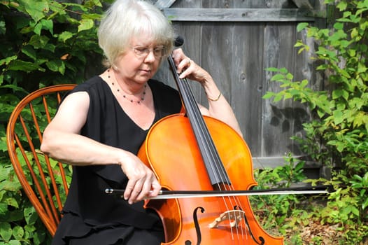 Female cellist performing a classical solo outdoors.