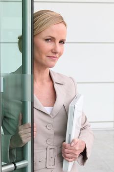 Blonde woman with a laptop in her arms