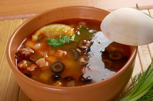 Solyanka on the plate.Solyanka, Russian soup with beef,sausage,chicken and lemon, olives