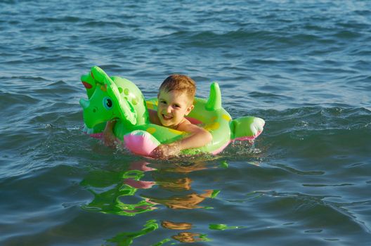 Little boy in the waves on the sea beach