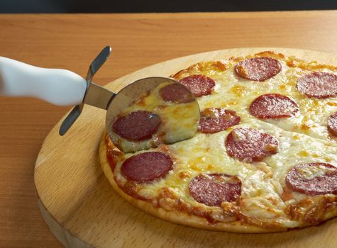 homemade pizza  Pepperoni.Closeup  a knife cut the pizza 