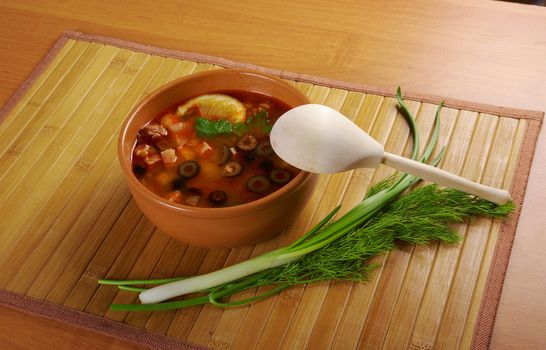 Solyanka on the plate.Solyanka, Russian soup with beef,sausage,chicken and lemon, olives