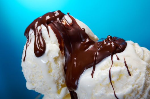 ice cream in with chocolate sauce. closeup .on blue background.