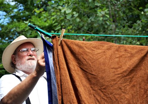 Country gentleman washing his clothes at his rural home.