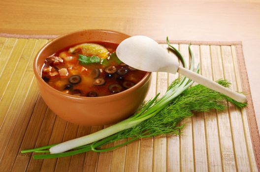 Solyanka on the plate.Solyanka, Russian soup with beef,sausage,chicken and lemon, olives
