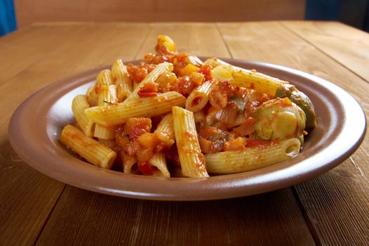 Italian Penne rigate pasta  with  vegetable  tomato sauce  on wooden table