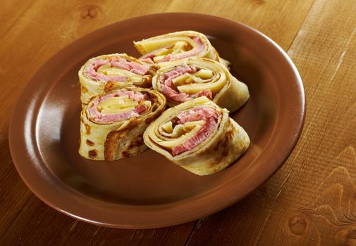 rolled pancakes stuffed ham and cheese. Shallow depth-of-field.