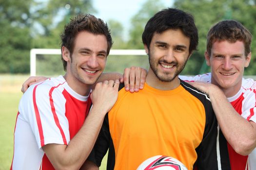 Three young football players on a football field.