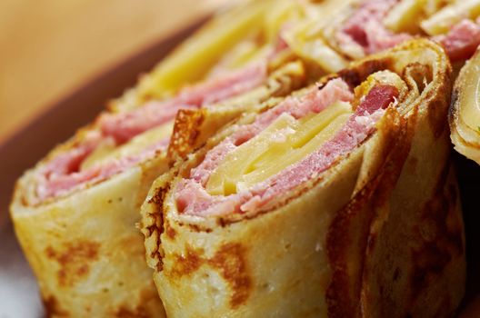 rolled pancakes stuffed ham and cheese. Shallow depth-of-field.