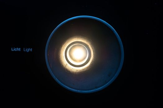 abstract light concept: Light shining through a tube with text light (in English and German) next to it