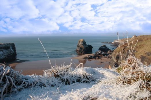 snow covered view of beach cliffs and the virgin rock in ballybunion county kerry ireland