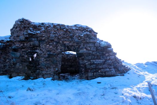 an old ruin in a seasonal crisp snow frosty covered grass ditch in ireland