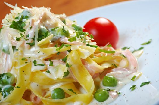 pasta Fettuccine Alfredo with cherry tomato, ham. close-up