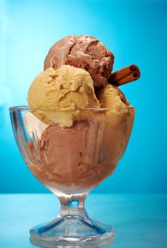 ice cream in with strawberries and chocolate. closeup .on blue background.