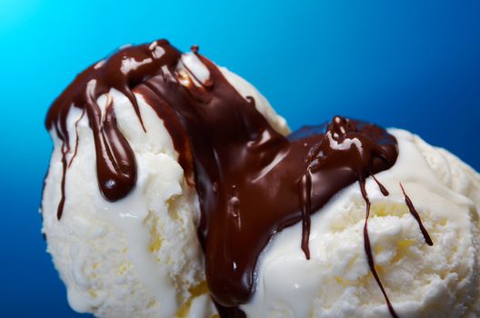 ice cream in with chocolate sauce. closeup .on blue background.